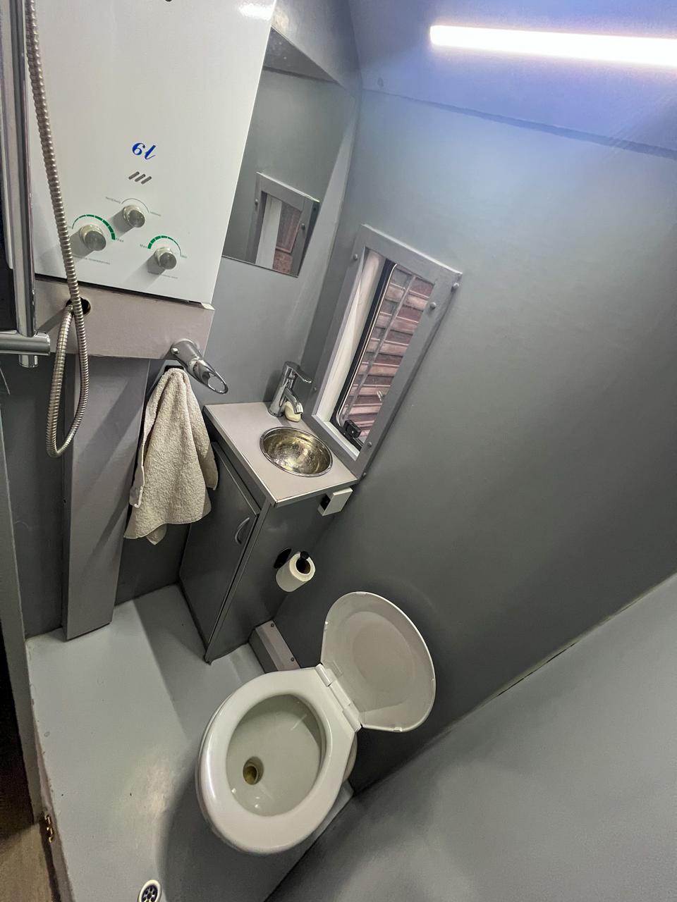Baño con inodoro náutico, ducha, calefón y bacha